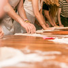 People kneading dough on a table