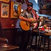 A man playing a guitar in a bar