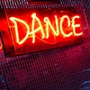 A lit up red Dance sign on a wall