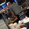 The back of a chef preparing food in a Milanos kitchen