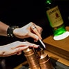 Close up of a hand spraying an atomiser onto a small piece of paper on the ingredients table at Jameson Whiskey distillery