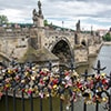 Locks on a fence in Prague, with a bridge in the background