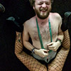 A man with his boxers around his neck, with a stripper's legs around him
