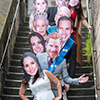 People wearing Royal Family masks posing on some stairs