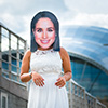 A girl in a wedding dress wearing a Meghan Markle mask, in front of The Sage in Newcastle