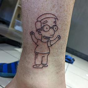 A tattoo of Simpsons character Milhouse Van Houten on a male's leg