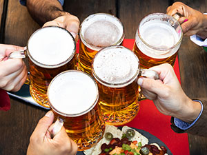 Five men holding tankards of beer