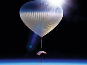 World View balloon floating into the black sky with sun shining from the top of the balloon 