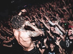 A topless man singing to a crowd