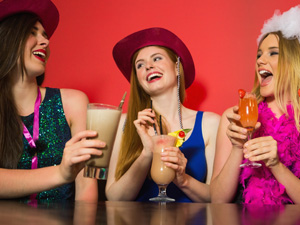 Three girls having fun and drinking cocktails on a hen do 