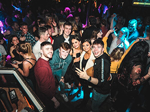 A group of men and women dancing in a nightclub