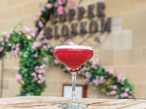 A close up of a cocktail on a wooden table with 