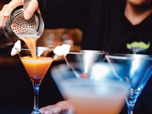 A close up of a bartender making a drink