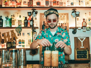 A bartender serving drinks behind a bar