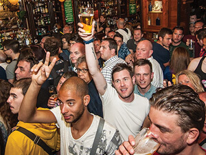 A group of men celebrating in a pub