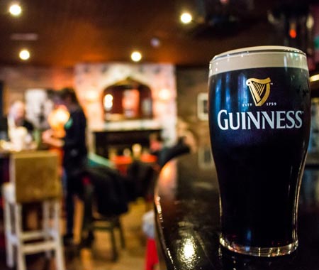 A pint of Guinness with a blurred bar in the background