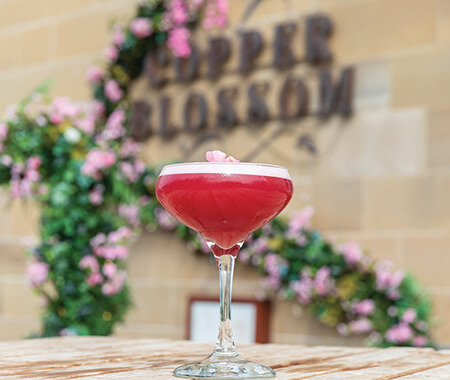 A close up of a cocktail on a wooden table with 