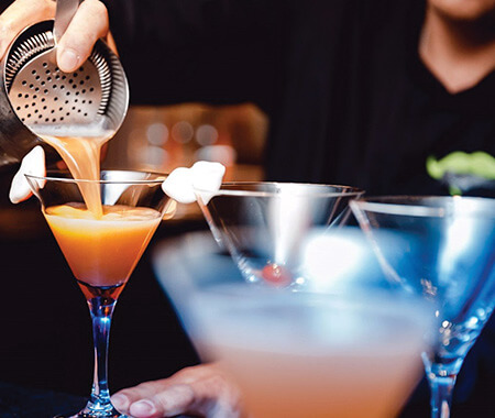 A close up of a bartender making a drink
