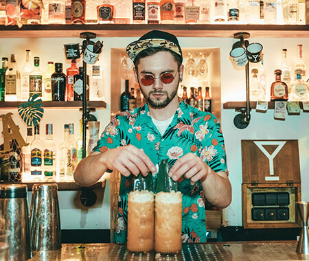 A bartender serving drinks behind a bar