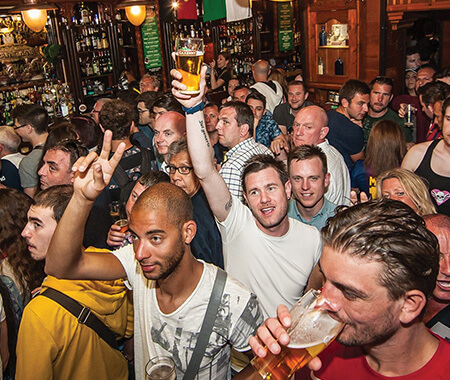 A group of men celebrating in a pub