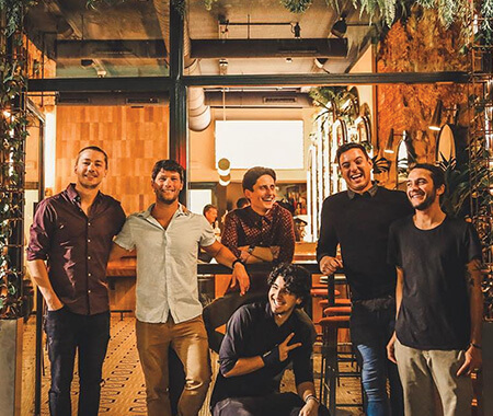 A group of men smiling in a bar