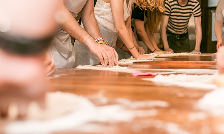 People kneading dough on a table