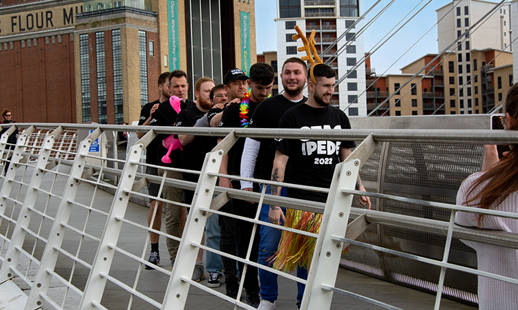 8 guys wearing a multi person t-shirt on the Millennium bridge, Newcastle