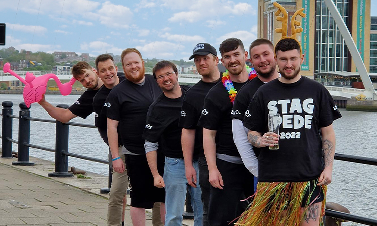 8 guys wearing a multi person t-shirt next to the Millennium bridge, Newcastle