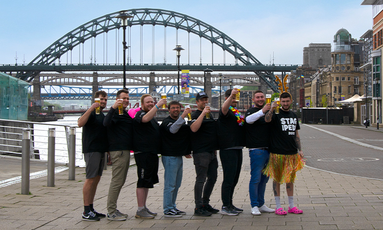 8 guys wearing a multi person t-shirt under the Tyne bridge, Newcastle