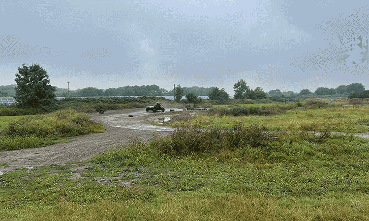 A gif of a person driving a rage buggie around a corner of a mud track at Max Events in Bristol. 