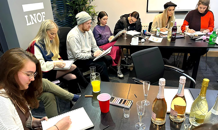 Several female members of LNOF staff and one male concentrating on drawing in their sketchbooks