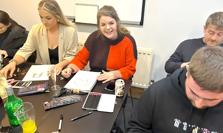 Female and male LNOF staff concentrating on drawing