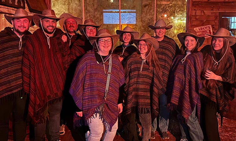 Team LNOF wearing cowboy hats and ponchos at Moonshine Saloon