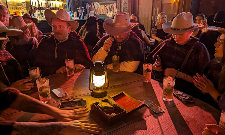 Team LNOF sat at a table wearing cowboy hats at Moonshine Saloon in Liverpool