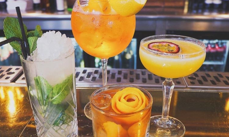 Four various drinks set on a bar top