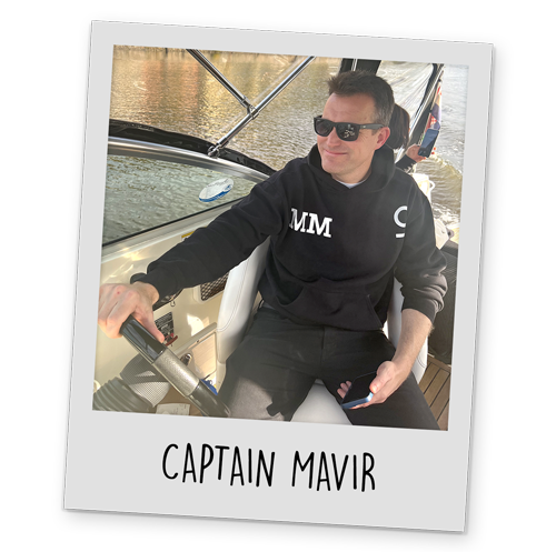 A polaroid style image of a our MD driving a boat in Prague, with text reading 'Captain Mavir' at the bottom