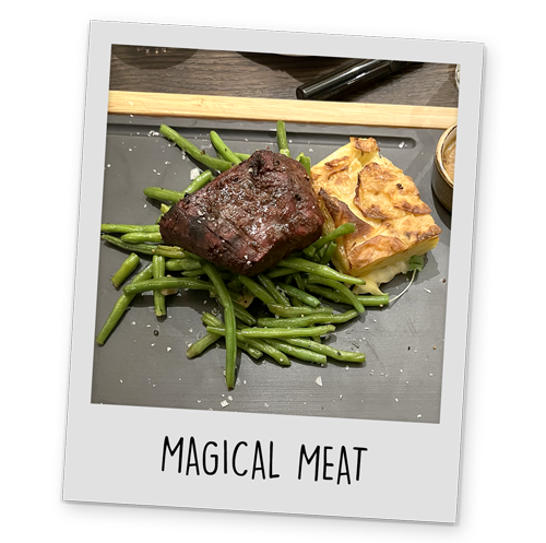 A polaroid style image of a plate of steak, potatoes and green beans, with text reading 'Magical Meat' at the bottom