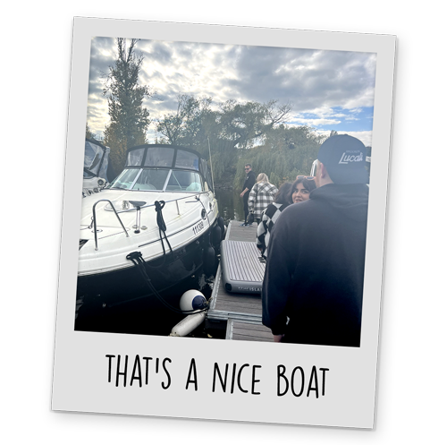 A polaroid style image of a team LNOF walking towards a boat, with text reading 'That's A Nice Boat' at the bottom