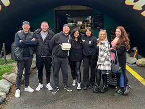 A group of 7 people standing in front of a go karting venue in Prague