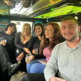A group of people smiling for the camera in a limo