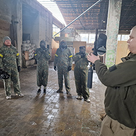  A group of people being shown how to use a paintball gun