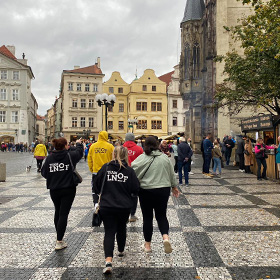  A group of people walking through Prague in LNOF hoodies