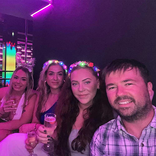 four members of our team chilling out with drinks in the funky purple lights of the La Bamba bar 