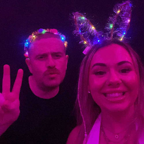 A male member of our team wearing a multicoloured light up headband and a female member of our team wearing multicoloured light up bunny ears at the La Bamba bar 
