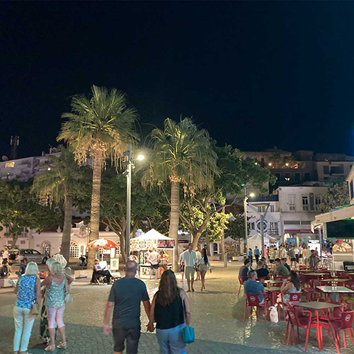  The Old Town of Albufeira at night with outdoor seating and palm trees 