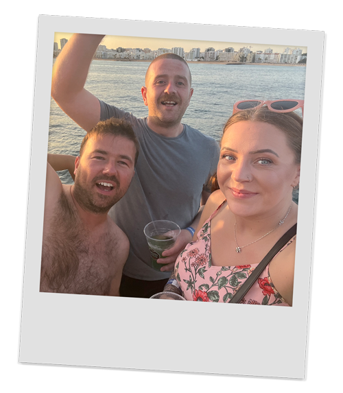 Three members of our team, two men and a woman enjoying their drinks on the boat
