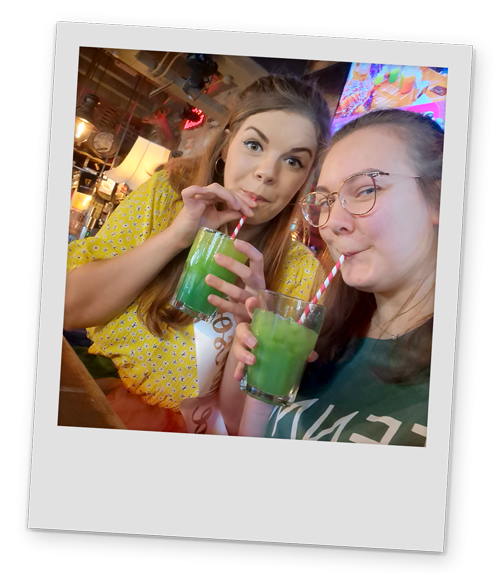 Two female members of staff in Granny Annies posing with green cocktails