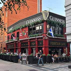  The outside of a traditional looking pub with Guinness written on the top. 