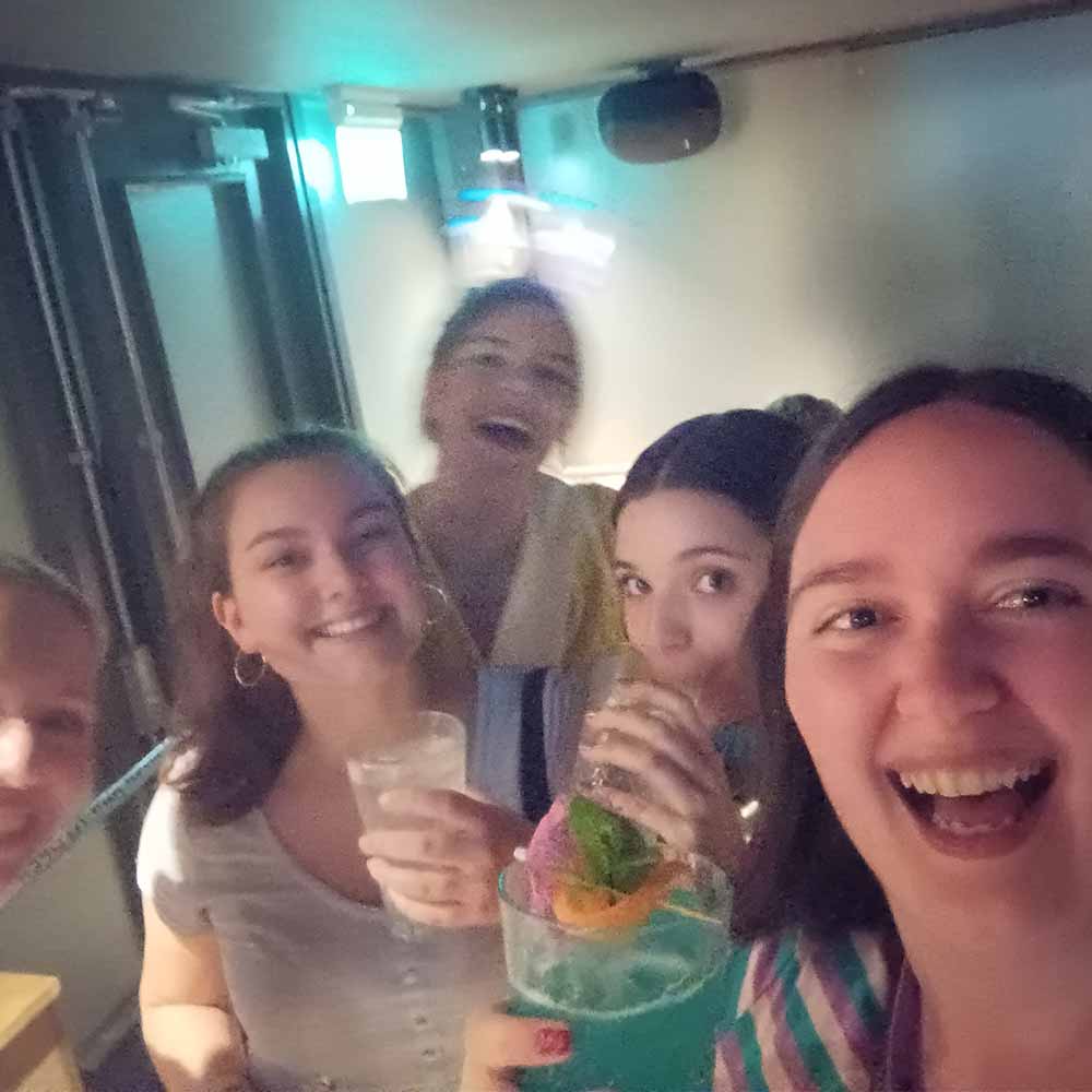  Four female members of LNOF's team taking part in the guided bar crawl with drinks in hand 
