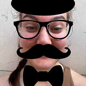  A female member of our team with an app filter on that consists of a top hat, glasses, a moustache and a bow tie 